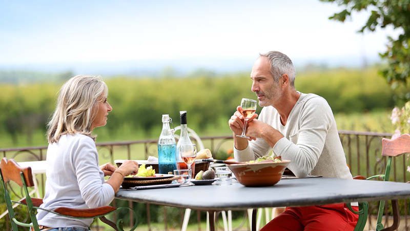 Par som ter lunch och dricker vin p en vingrd i Portugal.
